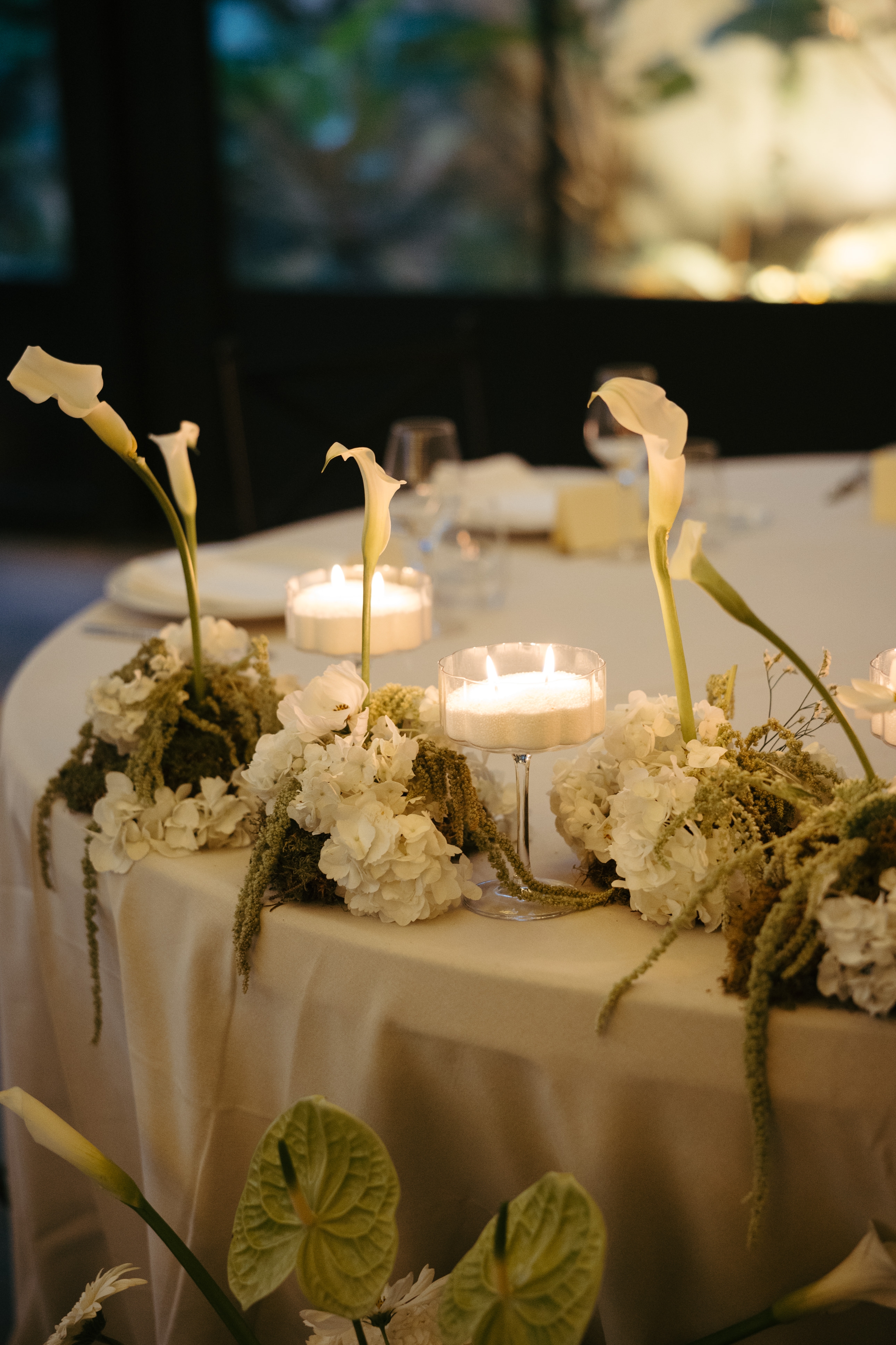Centro de mesa de boda con velas y calas blancas