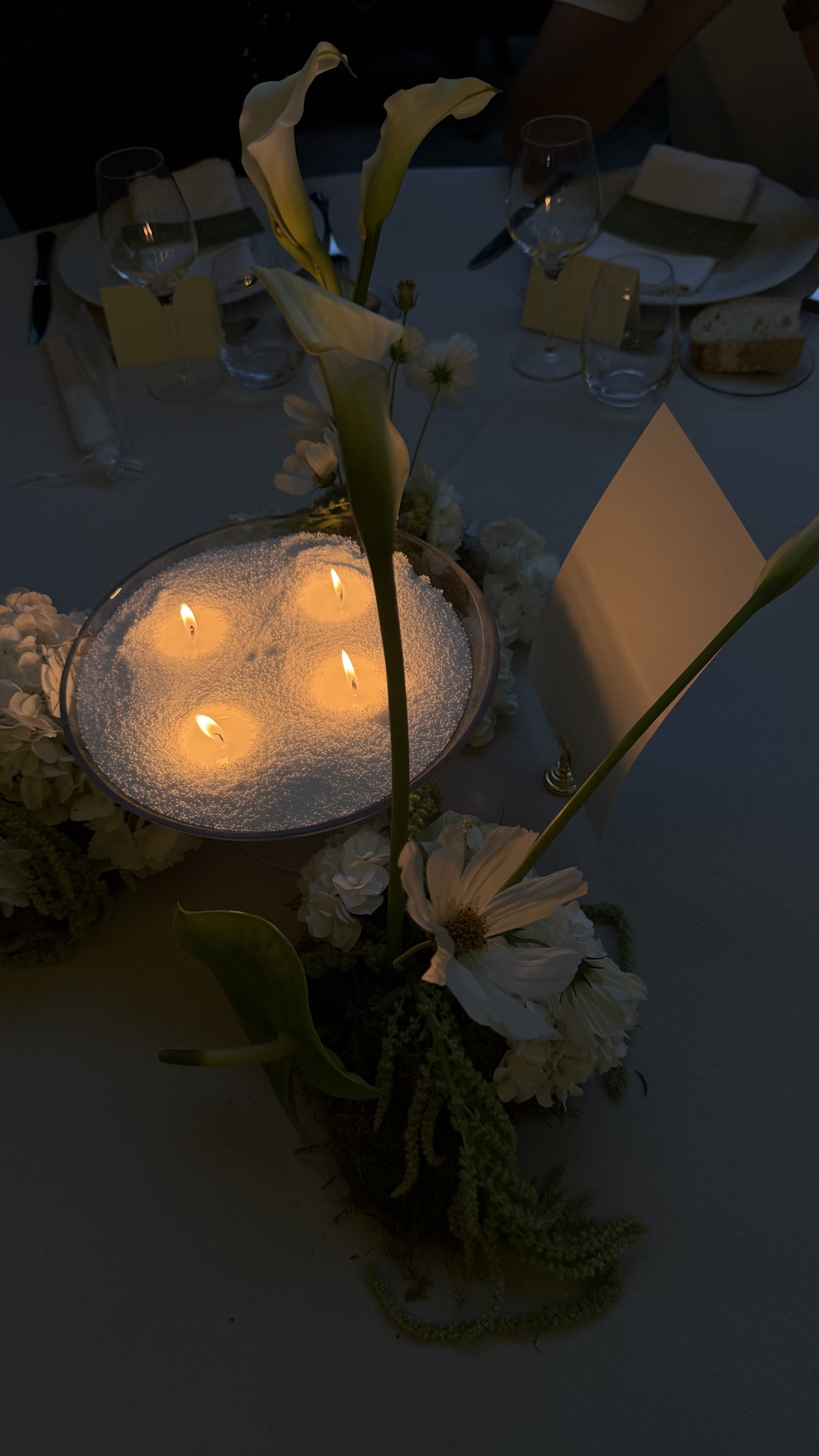 Mesas de banquete decoradas con velas al anochecer